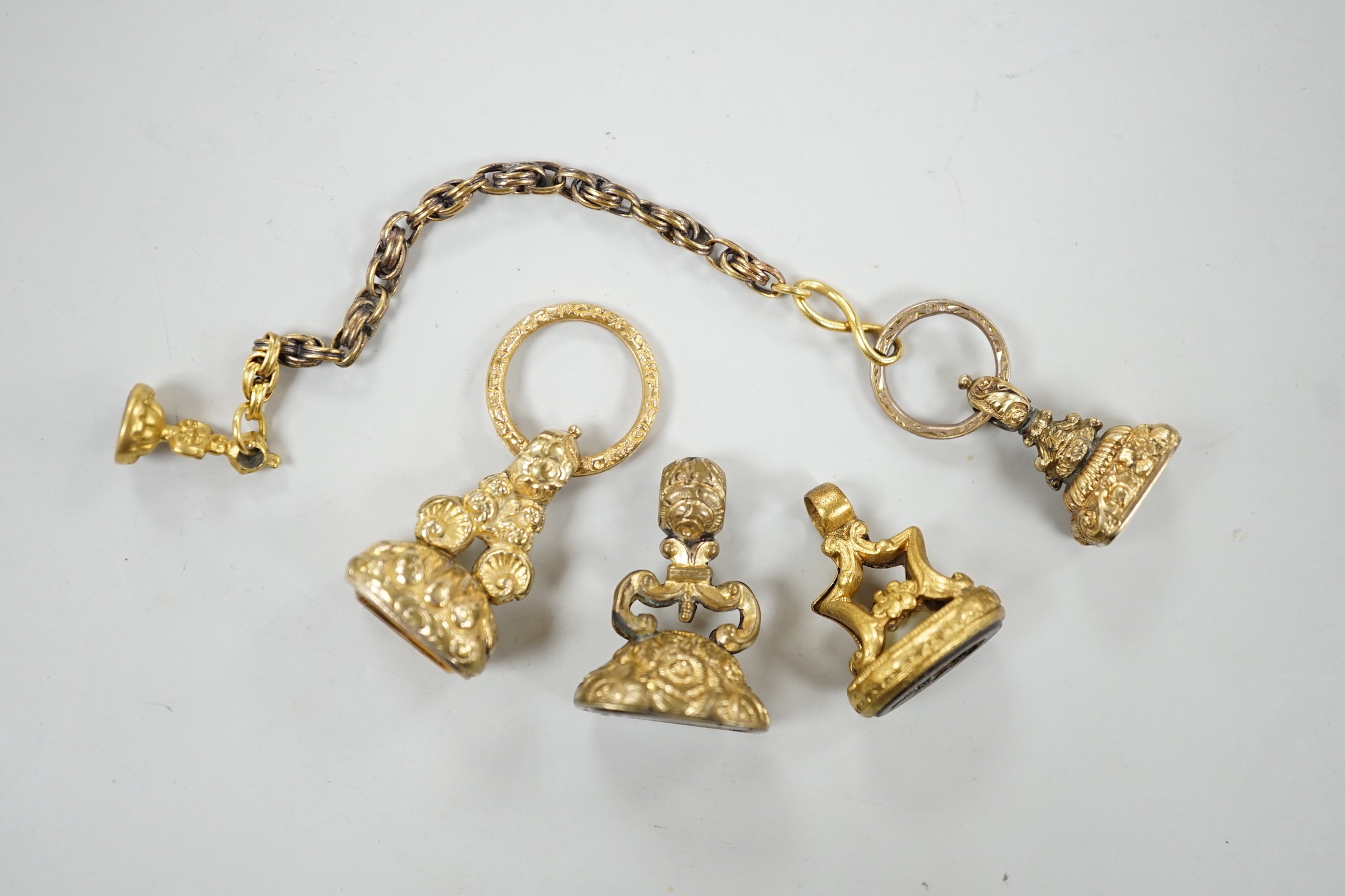 Four assorted 19th century gold plated fob seals, set with citrine, glass or carnelian, largest 30mm.